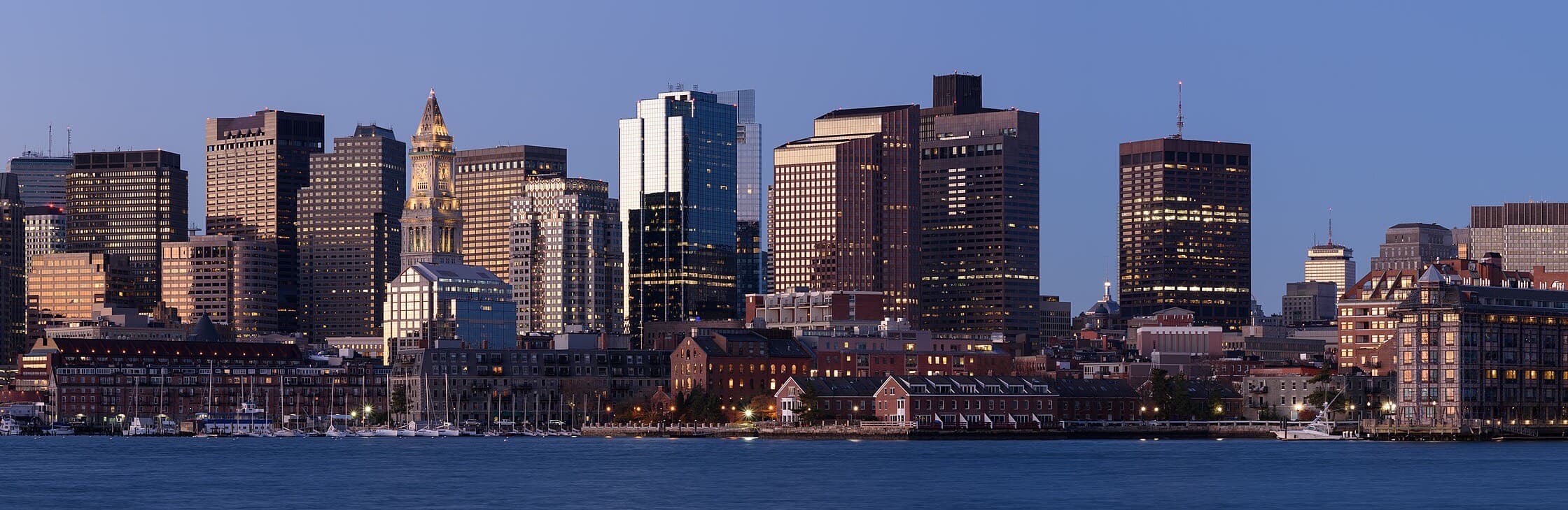 The Boston skyline at dusk, seen across the harbor from East Boston